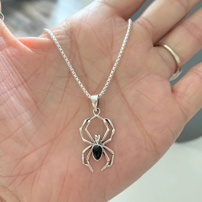 Le pendentif araignee pose dans une paume, qui donne son echelle
